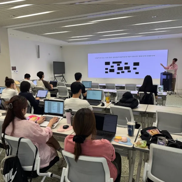 슈퍼플래닝 강사가 화면기획 사례를 설명하고 참석자들이 노트북으로 문서를 작성하는 UI/UX 기업교육 현장